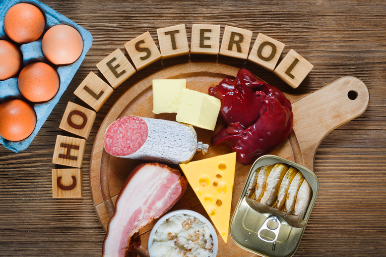 High Cholesterol Foods on a Circular Cutting Board 